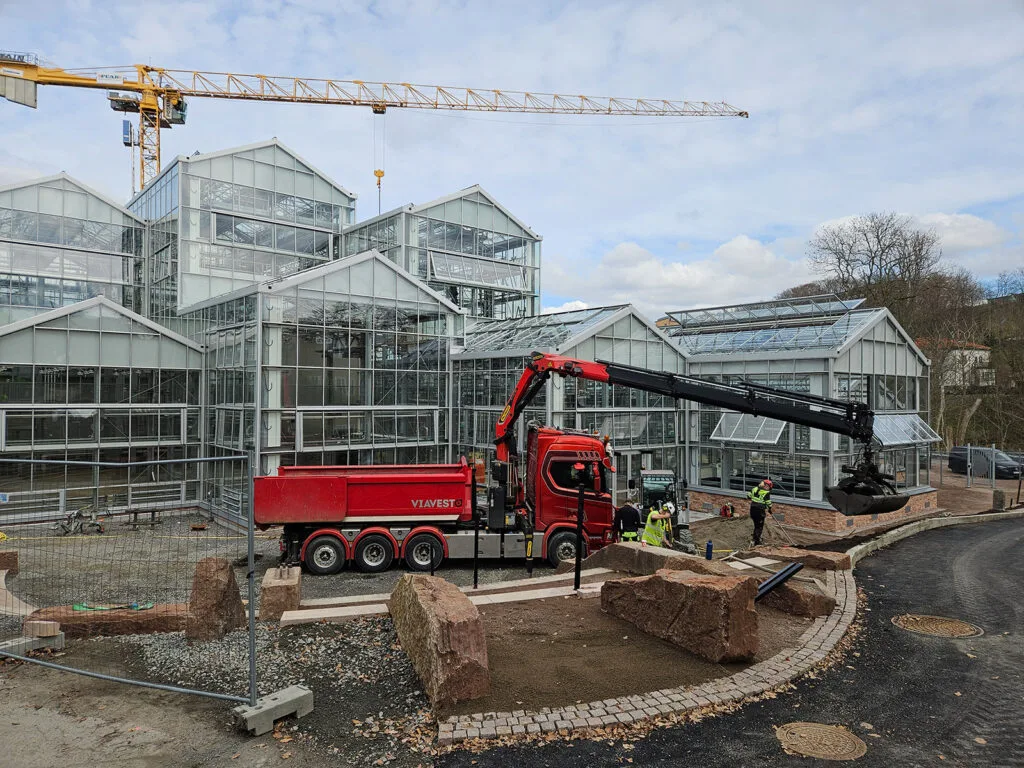Kranbil från Viavest på plats vid nyanläggning av rabatt framför växthus i Göteborgs botaniska trädgård